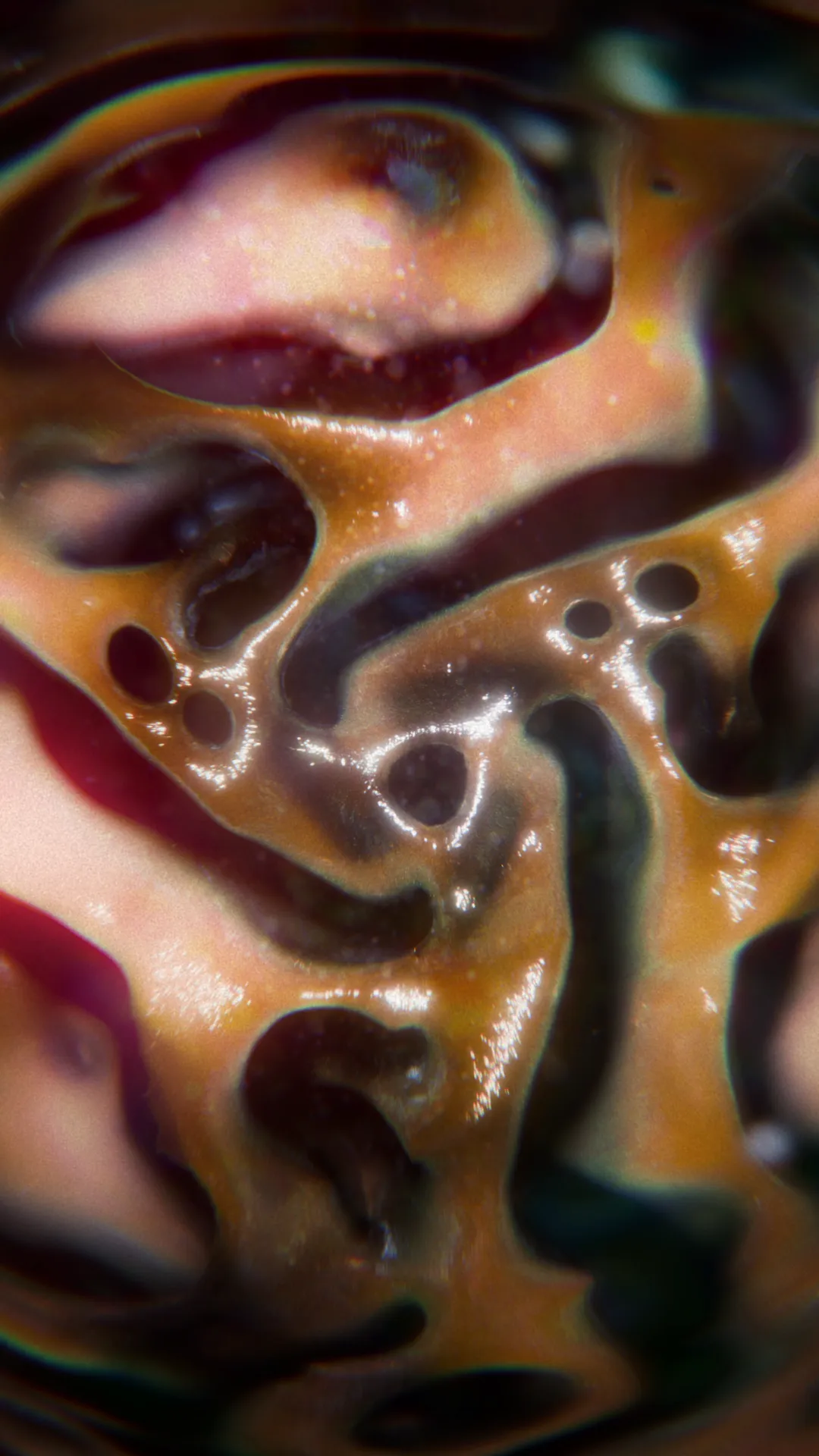 High-end CGI material study of a dark, viscous fluid with swirls of orange and teal, demonstrating realistic reflections and fluid dynamics.